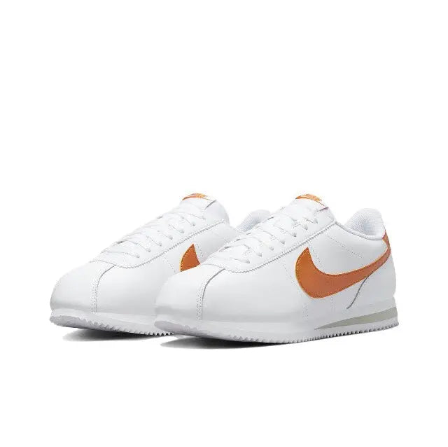 Cortez sneakers, side view: white leather with orange Swoosh and lace-up detail