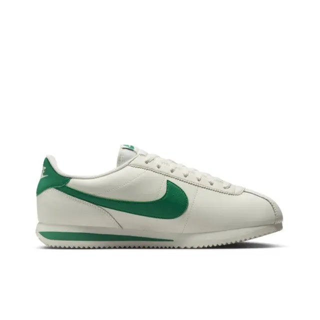 Low-top sneakers side view, white leather with green Swoosh and stripe