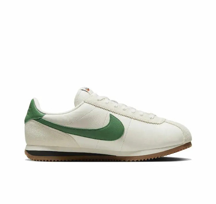 Low-top sneakers profile, white leather with green swoosh and gum sole