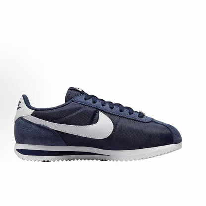 Side view of dark blue low-top sneakers with white swoosh and textured sole