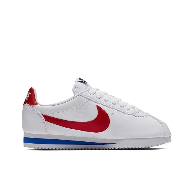 White Nike Cortez sneakers in side view with red swoosh and blue sole trim