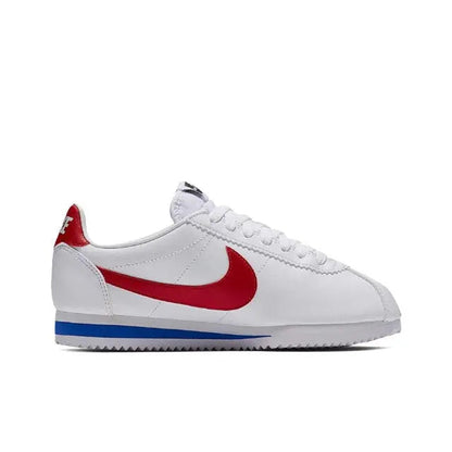 White Nike Cortez sneakers in side view with red swoosh and blue sole trim