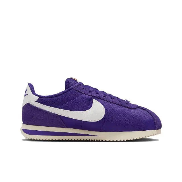 Purple low-top sneakers with white swoosh and lace-up front, side view