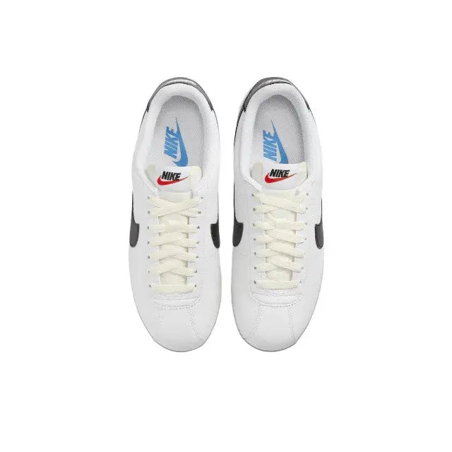 Nike Cortez sneakers, white laced pair with blue Nike logo on tongue
