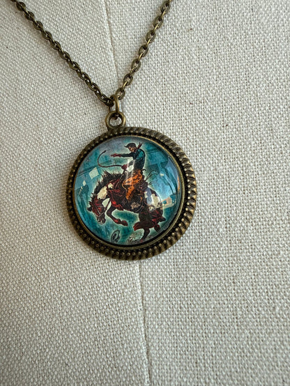 Close-up round glass pendant with bronc scene on bronze chain