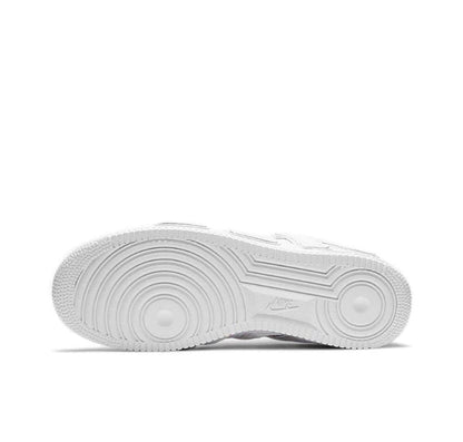 White low-top sneaker outsole with textured tread and circular traction pods.