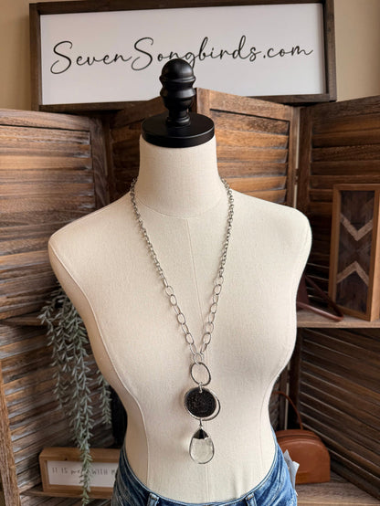 Coin and teardrop crystal pendant necklace with linked silver chain on mannequin