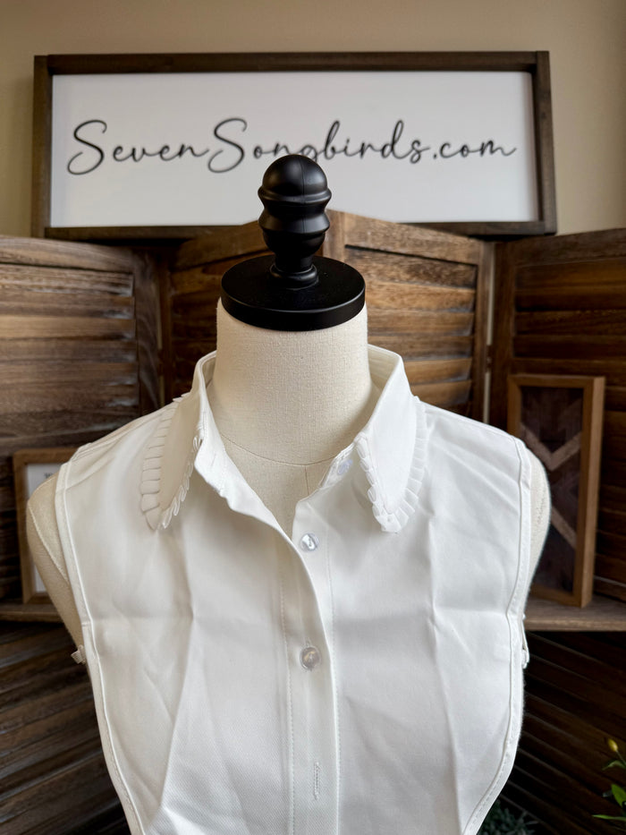 White faux shirt collar with raised ruffle trim and buttoned center front