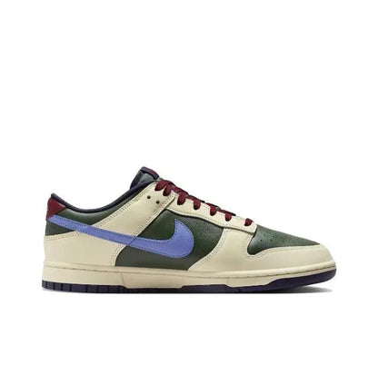 Nike Dunk Low sneakers in cream, green, burgundy, and navy with blue swoosh.