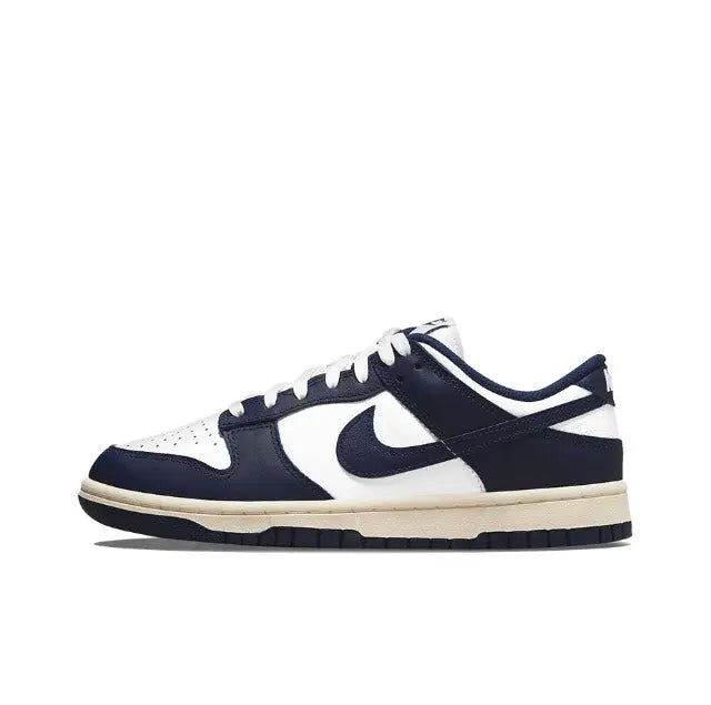 Low-top sneakers in white and navy with large swoosh and cream outsole