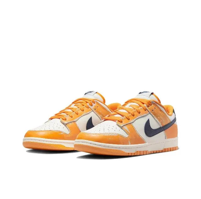 Low-top sneakers, side view, sail leather with orange panels and navy Swoosh