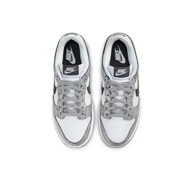 Low-top sneaker pair, white leather with silver speckled toe and black Nike logo