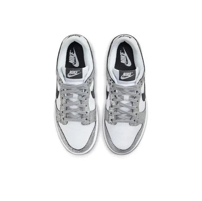 Low-top sneaker pair, white leather with silver speckled toe and black Nike logo