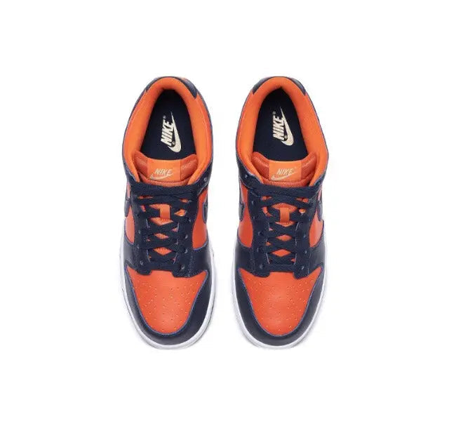 Nike Dunk Low sneakers, top view pair, navy with orange laces and Swoosh