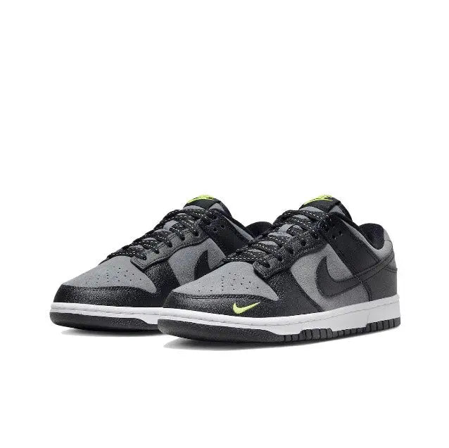 Low-top sneakers, black and gray with green accents on the Swoosh and tongue