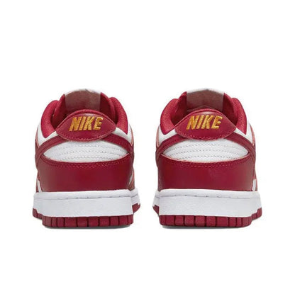 Nike Dunk Low sneakers heel view with yellow NIKE logo on red collar and white back panel