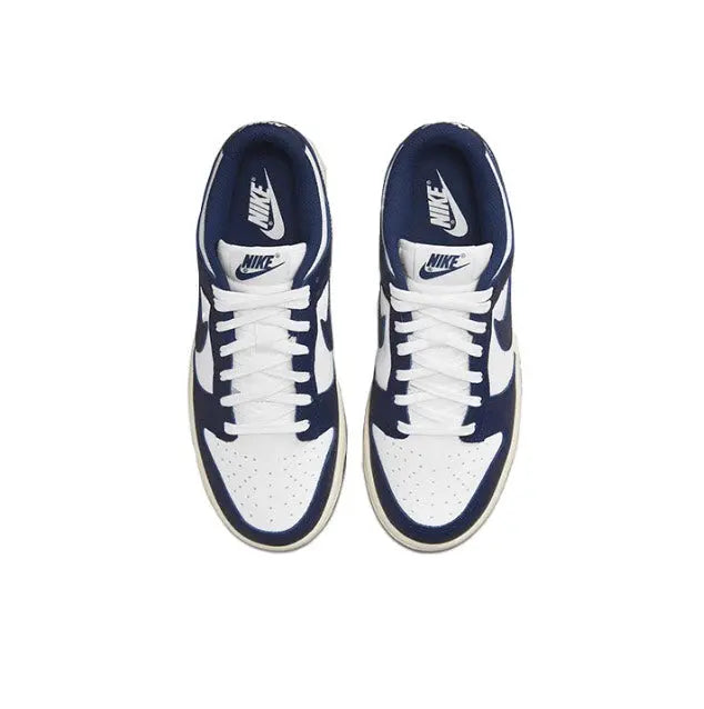 Low-top sneakers front view with white laces, navy collar, and navy Swoosh