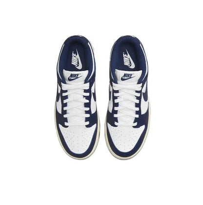 Low-top sneakers front view with white laces, navy collar, and navy Swoosh