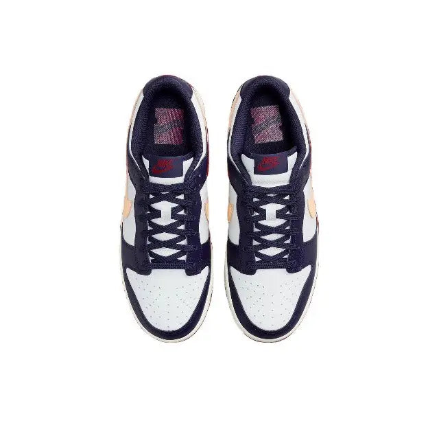 Pair of low-top sneakers seen from above with white toe panels and navy uppers