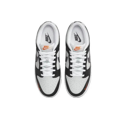 Low-top sneaker pair with black overlays, white panels, and orange swoosh accents