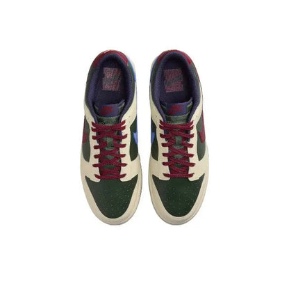 Low-top sneakers front view: cream toe, dark green overlays, red laces, navy lining.