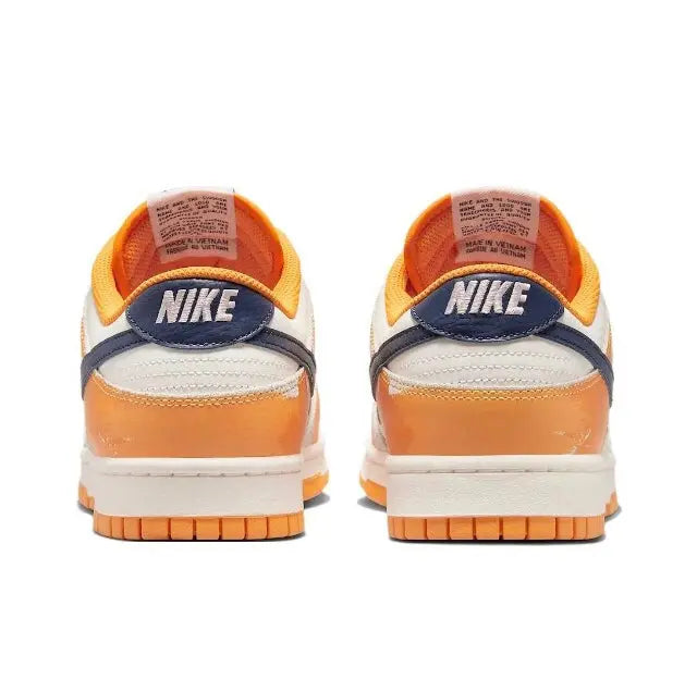 Low-top sneakers heel view with Nike branding, sail leather and orange trim