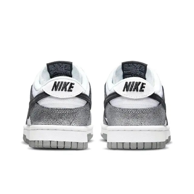 Low-top sneaker heel view, white leather with black Nike logo and silver toe
