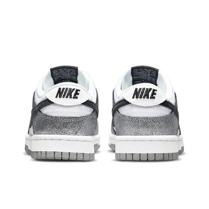 Low-top sneaker heel view, white leather with black Nike logo and silver toe