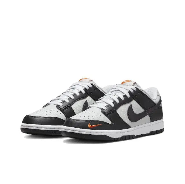 Low-top sneaker, black-and-white leather with orange swoosh on side