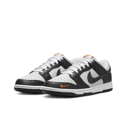 Low-top sneaker, black-and-white leather with orange swoosh on side