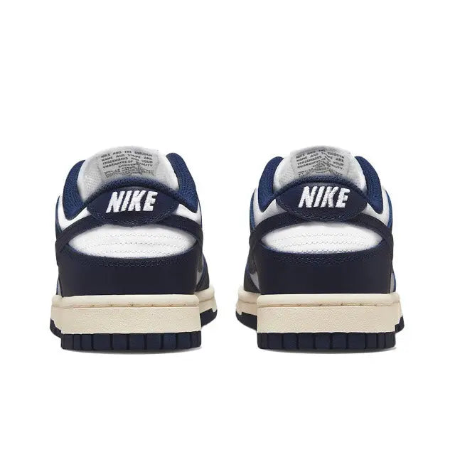 Low-top sneakers heel view with Nike branding, navy uppers, and cream sole