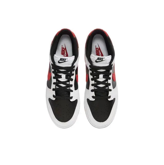 Low-top sneaker pair with white leather, black panels, red logo accents, and black laces