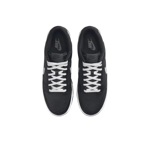 Low-top sneaker top view in black with white lace pattern and stitched panels