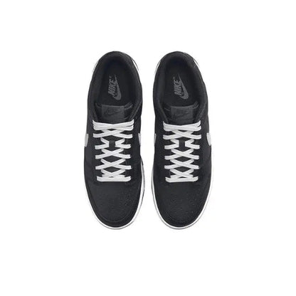 Low-top sneaker top view in black with white lace pattern and stitched panels