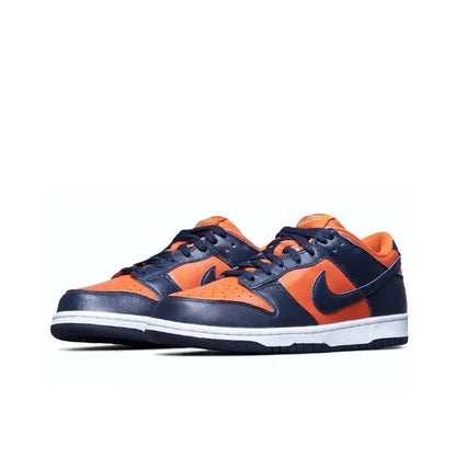 Nike Dunk Low sneakers, side view: navy suede with orange overlays and Swoosh