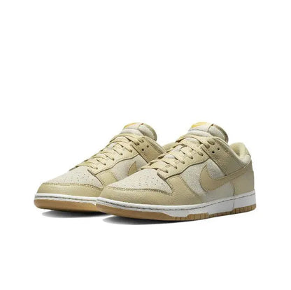 Nike Dunk Low sneakers pair, light beige leather with tan Swoosh and gum outsole