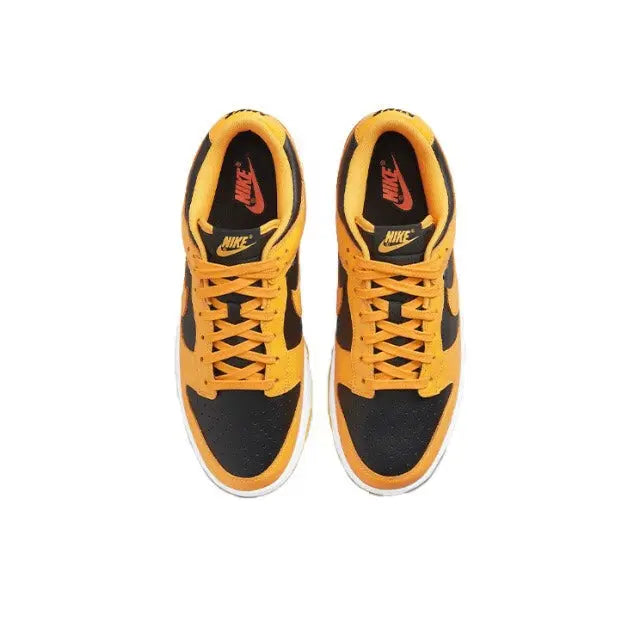 Low-top sneakers front view, orange laces over black toe panels and Nike Swoosh