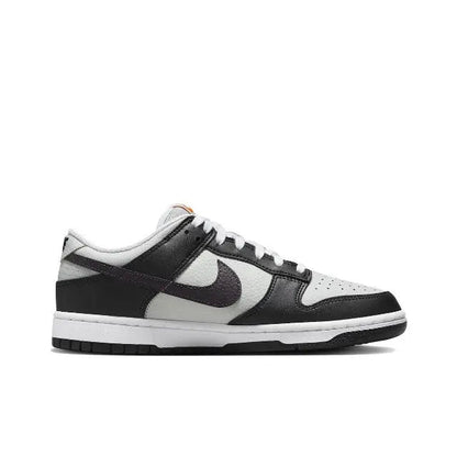 Low-top sneaker, white toe box with black panels and orange heel accent