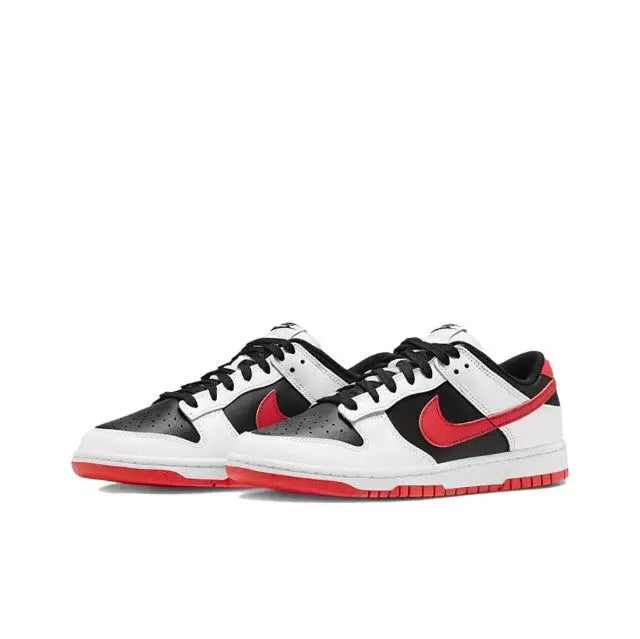 Low-top sneaker angled side view with white leather, black panels, and red swoosh