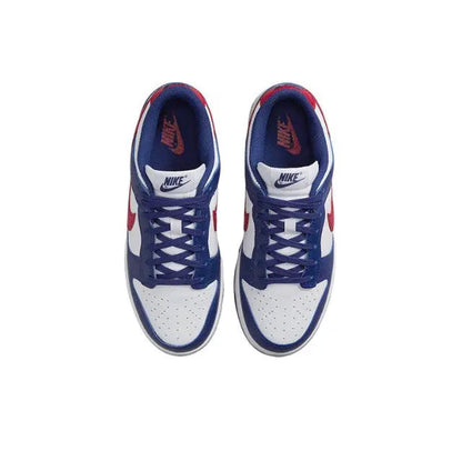 Low-top sneakers with blue overlays, white toe box, blue laces, and red swoosh.