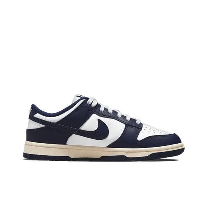Low-top sneakers side profile in navy and white with cream midsole and swoosh
