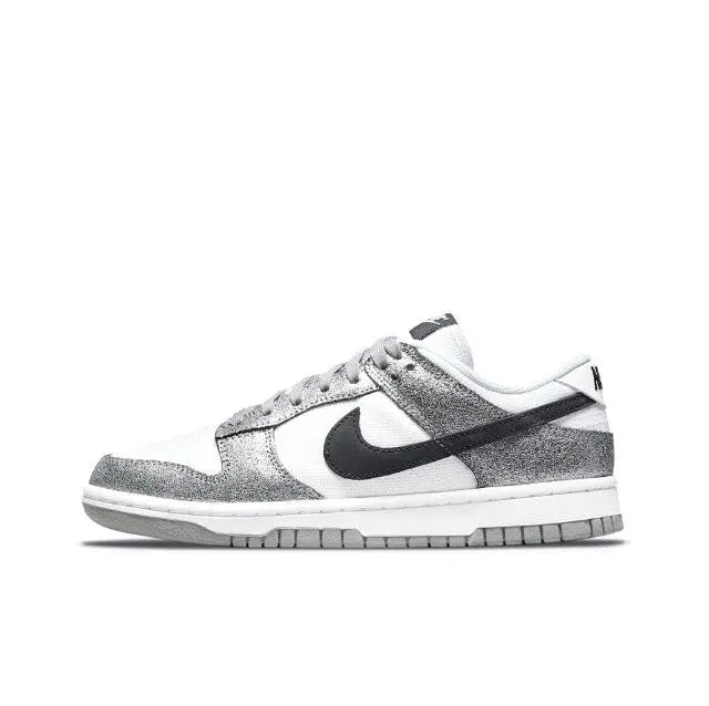 Low-top sneaker angled side view, white and silver panels with black Nike Swoosh