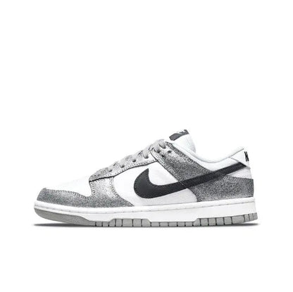 Low-top sneaker angled side view, white and silver panels with black Nike Swoosh