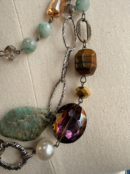 Layered necklace with silver chains, blue-green stone beads, faceted purple and tiger eye drops
