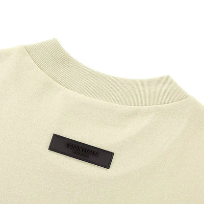 Light yellow T-shirt crewneck with black 'ESSENTIALS' label