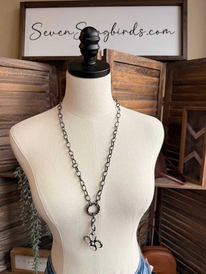 Floral crystal pendant necklace with long chain and flower charm on a mannequin bust