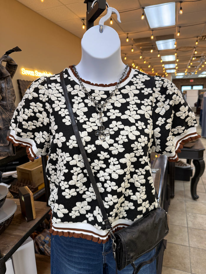 Black floral embossed knit puff-sleeve shirt with white flower pattern and ribbed hem