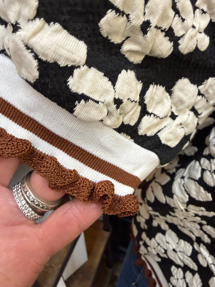 Floral embossed knit shirt hem with white stripe and brown ribbed trim