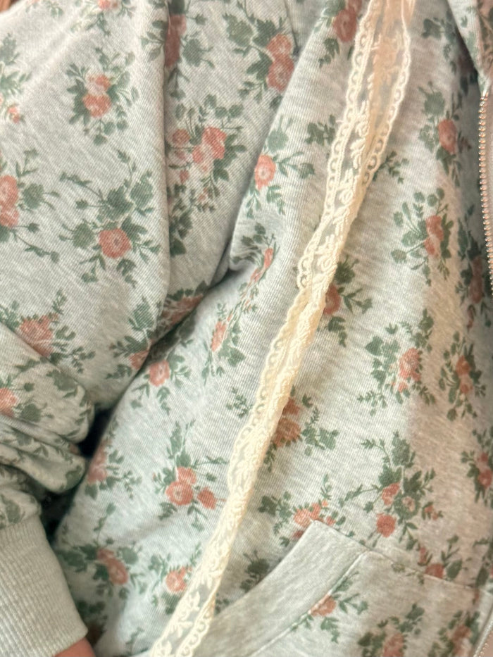 Mint floral hoodie fabric detail with cream lace trim along seam