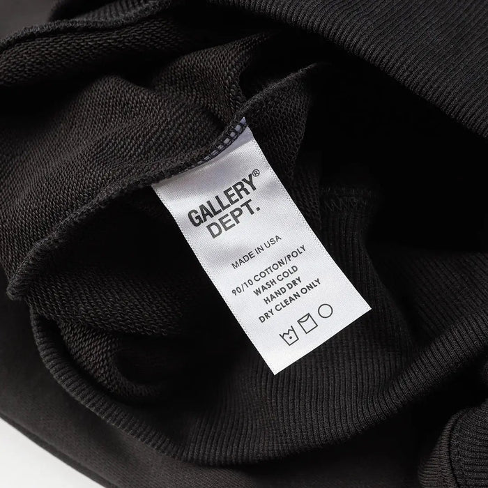 Black hoodie with attached care label showing wash and dry instructions